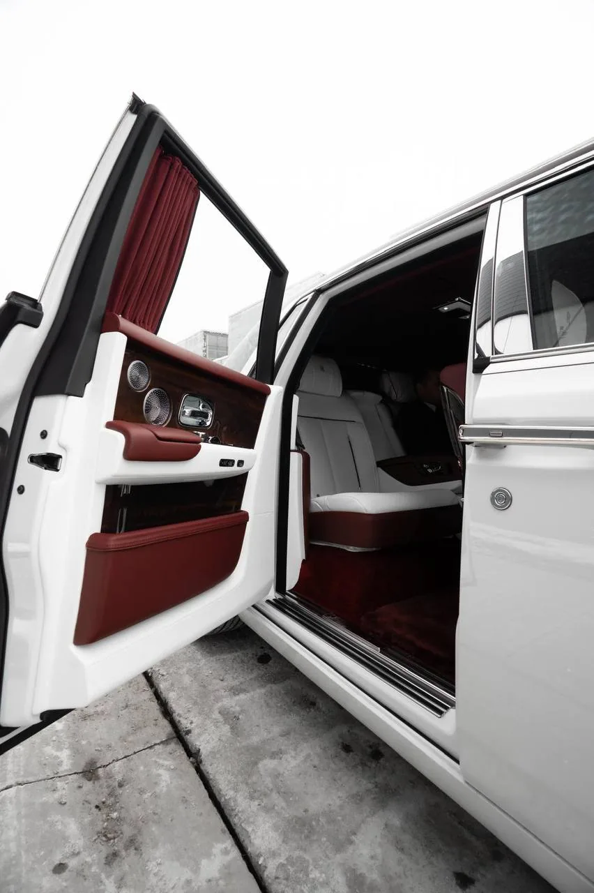 Rear coach door of a Rolls-Royce Phantom open to red leather
